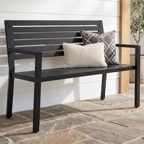 Metal patio bench with arms placed on a level outdoor surface
